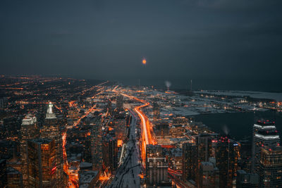 High angle view of illuminated buildings against sky at night