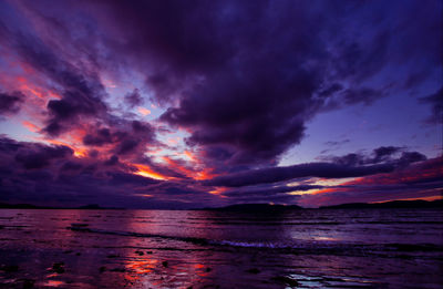 Scenic view of sea against dramatic sky during sunset