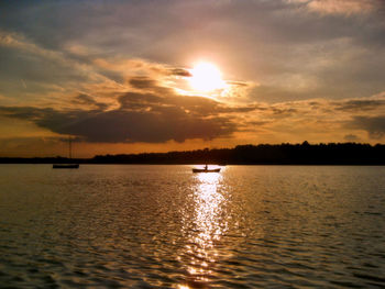 Sailboat sailing on sea against sky during sunset