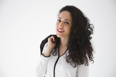 Portrait of smiling young woman against white background