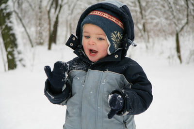 Boy smiling in snow during winter