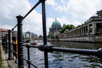 Berlin cathedral by river seen through railing in city