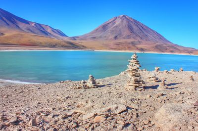 Scenic view of lake and mountains against clear blue sky