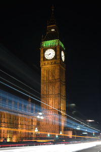 Low angle view of clock tower at night