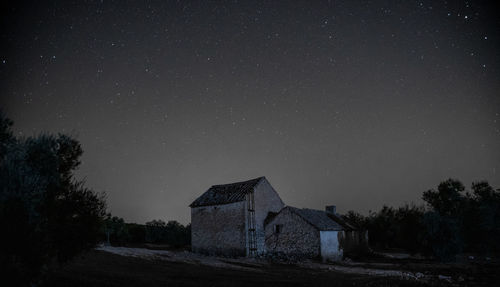 Abandoned house on field against sky at night