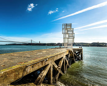 Bridge over sea against blue sky