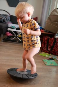 Cute boy standing on toy at home