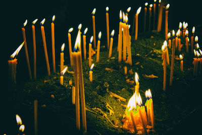 Close-up of lit candles in temple at night