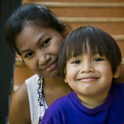 Portrait of smiling mother and son sitting on steps