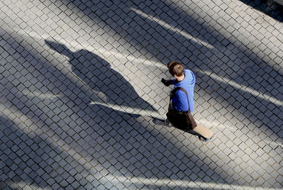 Directly above shot of man walking on cobblestone