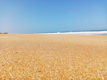 Surface level of beach against clear sky