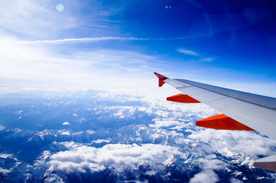 Cropped image of airplane flying over landscape during winter