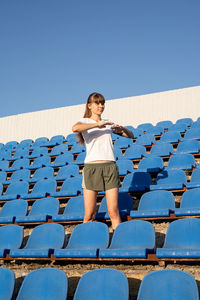 Full length of woman standing against clear blue sky