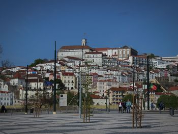 Buildings in city against clear blue sky