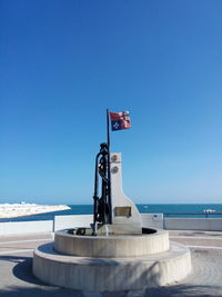 Flag waving at observation point against clear blue sky