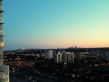 High angle view of illuminated buildings against clear sky at dusk