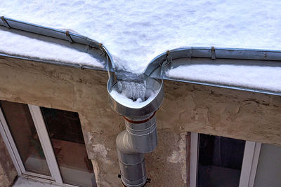 Low angle view of icicles on roof against sky