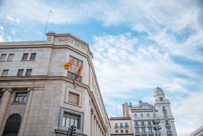 Low angle view of buildings against cloudy sky