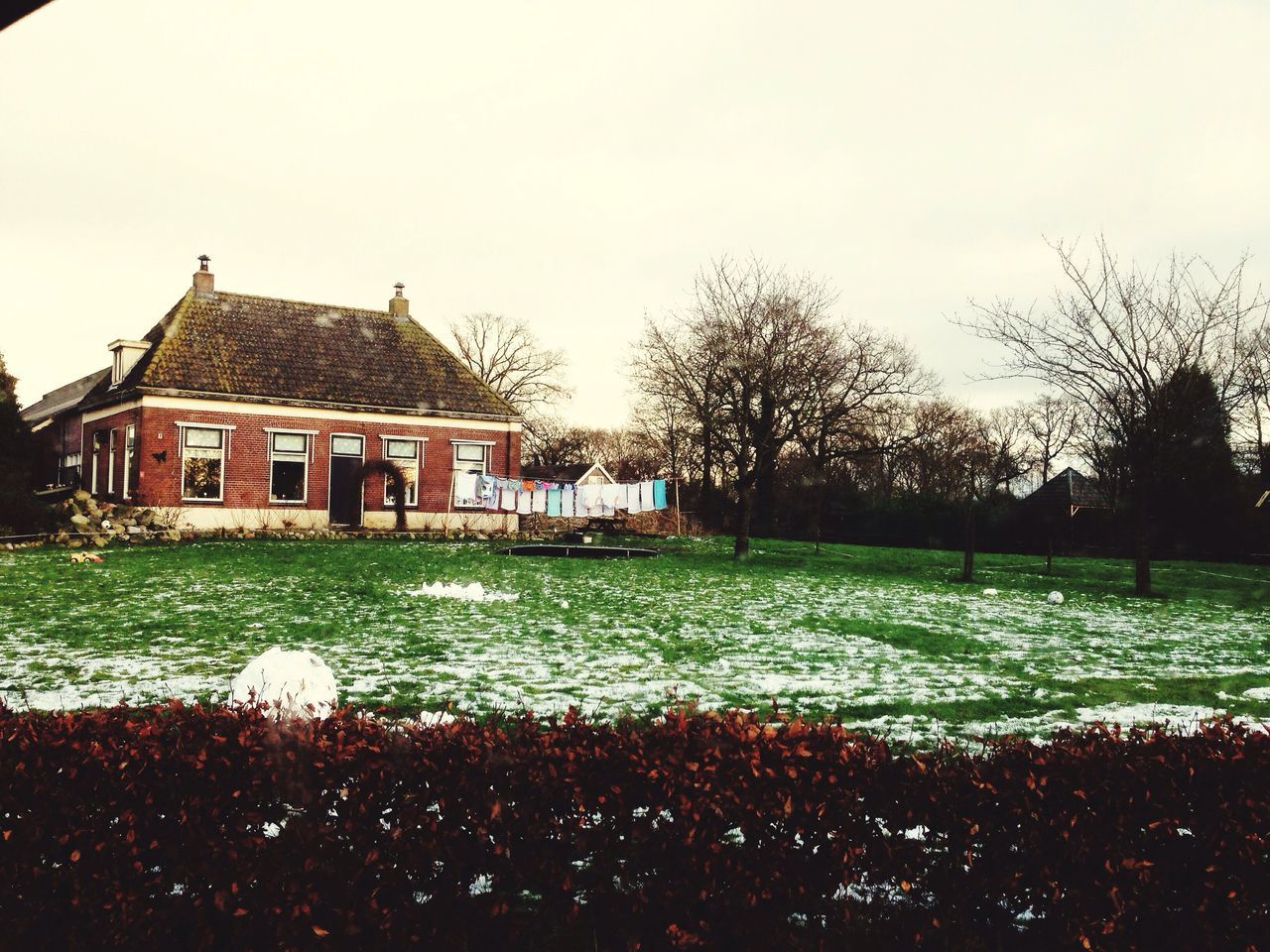 building exterior, architecture, built structure, tree, clear sky, sky, grass, water, house, outdoors, nature, lawn, field, copy space, day, dusk, pond, park - man made space, bare tree, religion