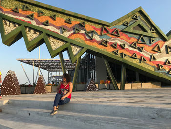 Woman by building against sky