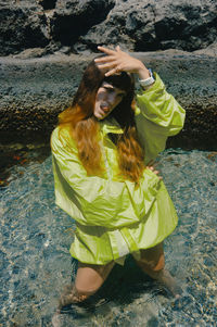 High angle view of young woman sitting on a lake 