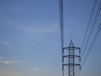 Low angle view of electricity pylon against sky