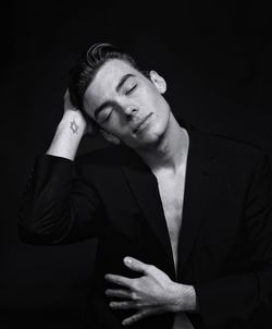 Close-up portrait of young man against black background