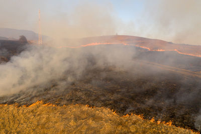 Aerial view of spring dry grass burning field. fire and smoke in the meadow, nature pollution