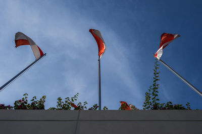 Low angle view of indonesia flags against blue sky