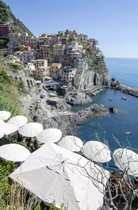 High angle view of buildings by sea against clear sky