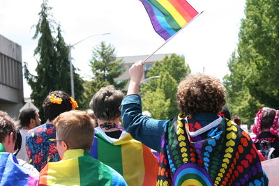 People walking with multi colored flags