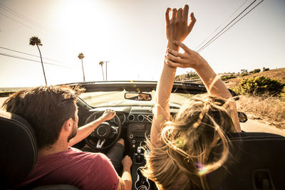 Rear view of friends sitting in car