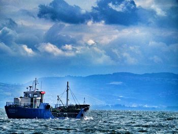 Ship sailing in sea against blue sky