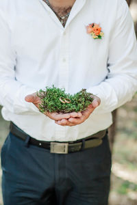 Midsection of man holding ice cream standing outdoors