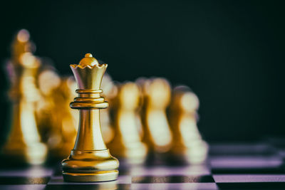 Close-up of chess pieces on board against black background