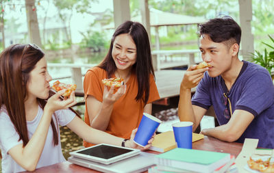 Young woman eating food while sitting at restaurant