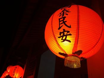 Low angle view of illuminated lanterns hanging at night