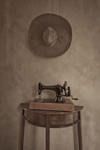 Old fashioned sewing machine on table against wall