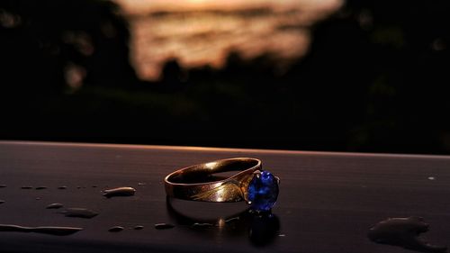 Close-up of engagement ring and sunset 