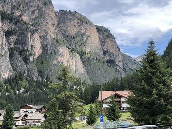 Houses by trees and mountains against sky