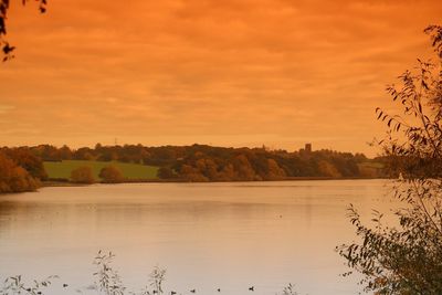 Scenic view of lake against orange sky