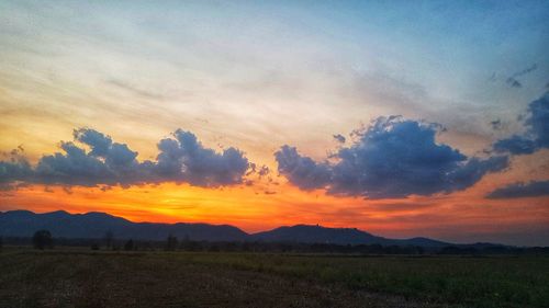 Scenic view of silhouette field against sky during sunset