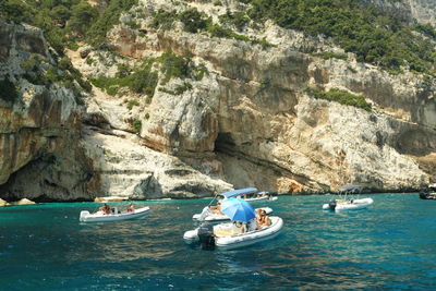 People on rock by sea