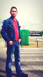 Portrait of young man standing against sky