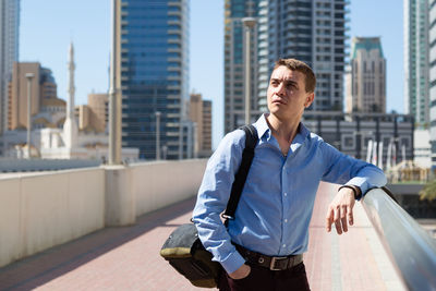 Man standing in city against buildings