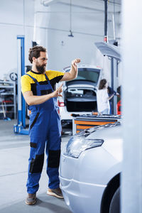 Side view of man holding car