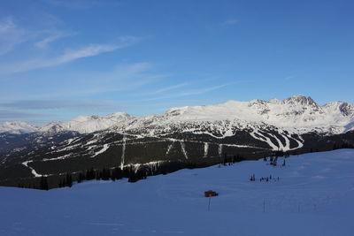 Scenic view of snowcapped mountains against blue sky