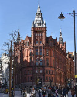 People on street against buildings in city