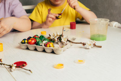 Midsection of woman holding christmas decoration on table