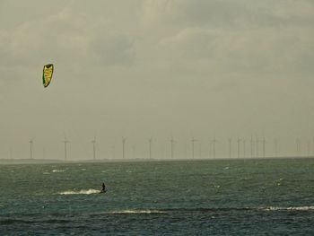 Scenic view of sea against sky with a kite surfer 